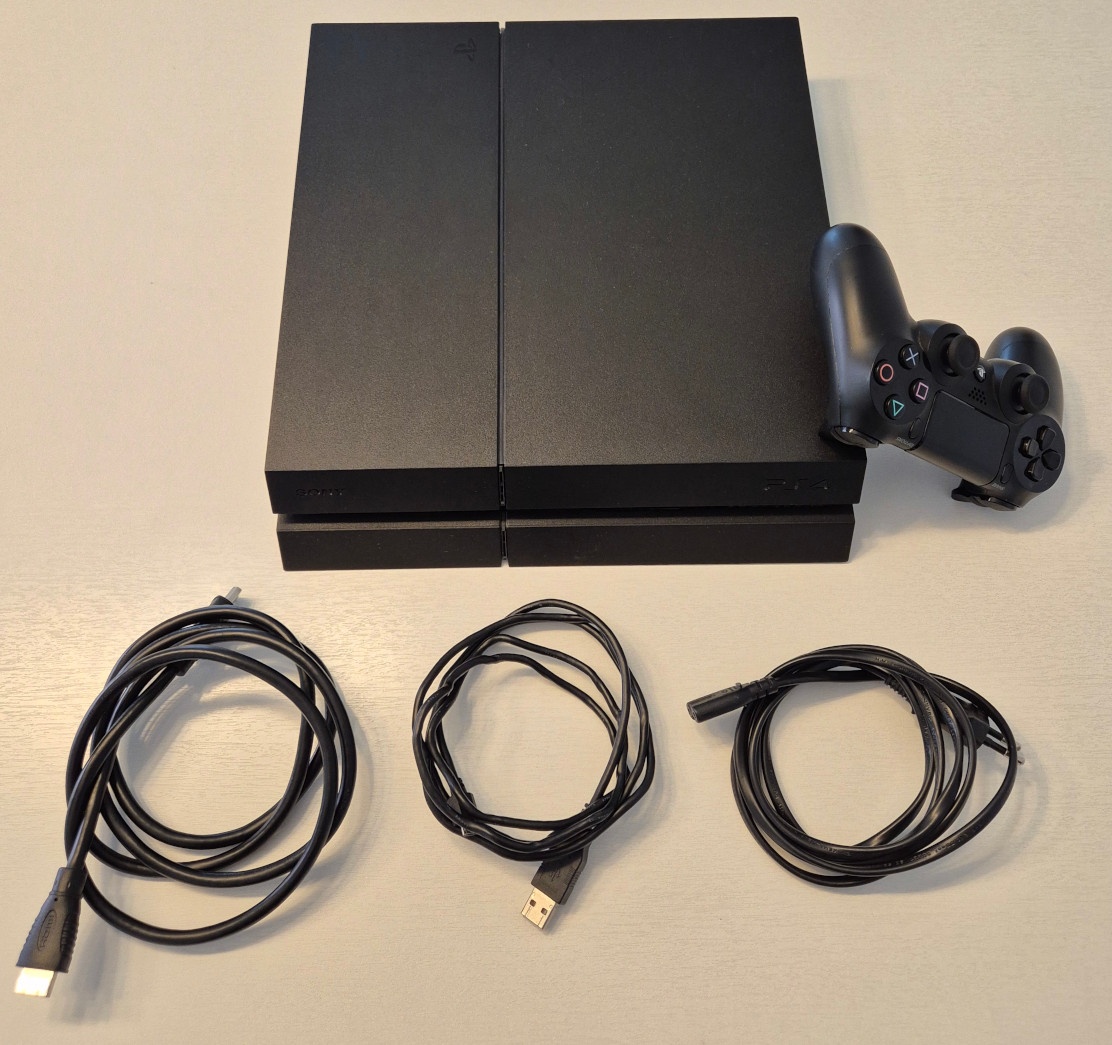 Herna konzola PlayStation 4 s original ovladacom a kablami.