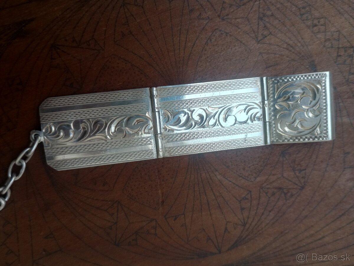 Strieborný starožitný prívesok k hodinkám.