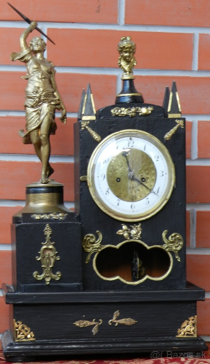 Hodiny stolové skriňkové, žena s oštepom v klasiciznom štýle