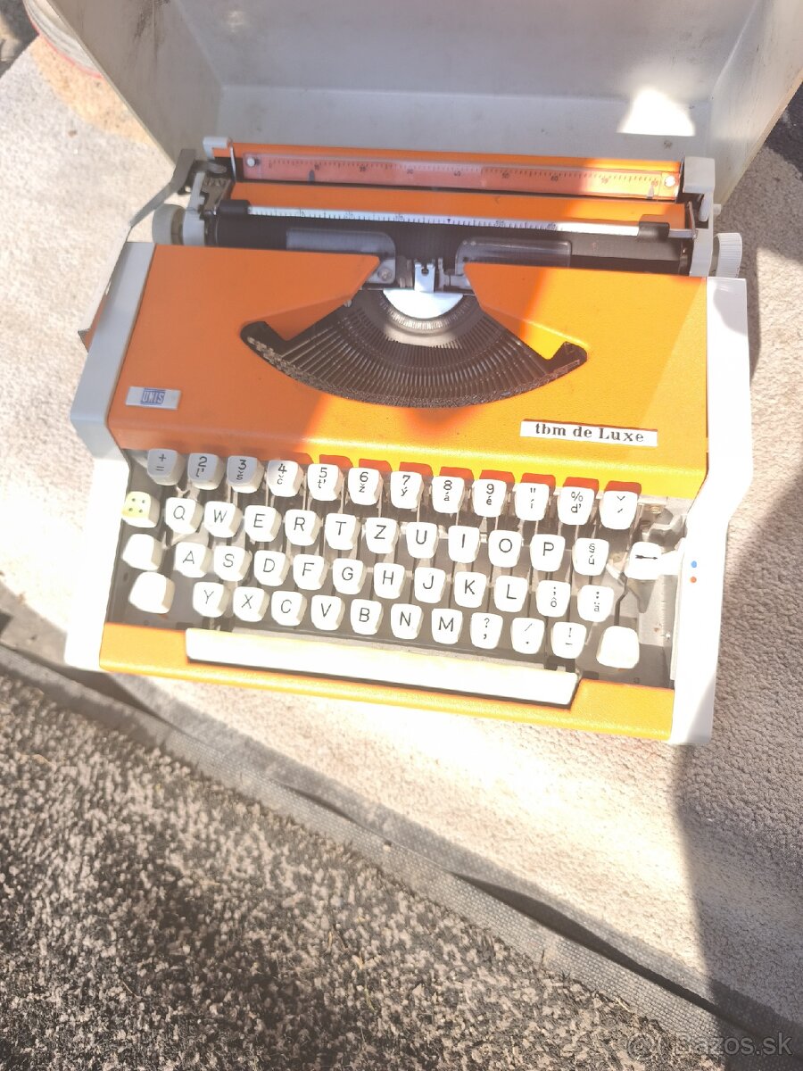 UNIS tbm de Luxe – oranžová písacia mašina, s obalom