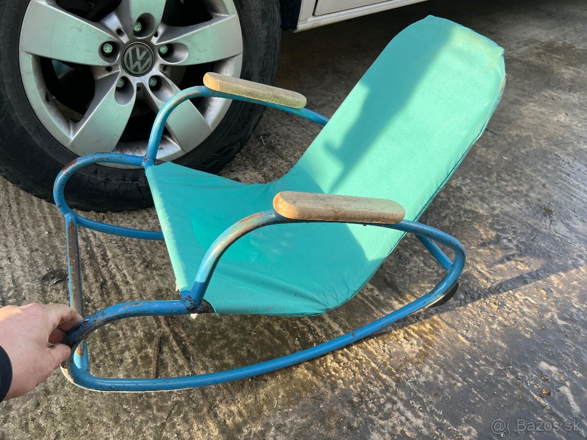 Staré detské kovové hojdacie kreslo.