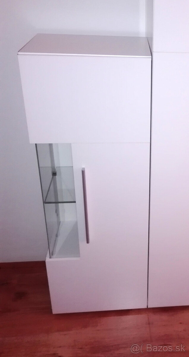 biela lesklá vitrína s preskleným rohom