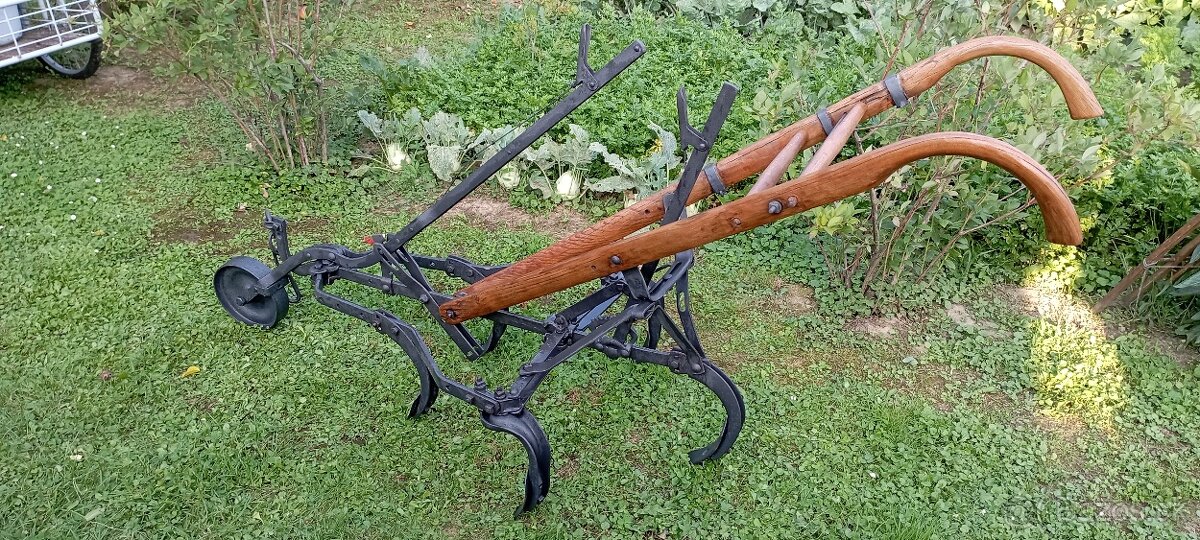 Starý kovový pluh s drevenými rúčkami