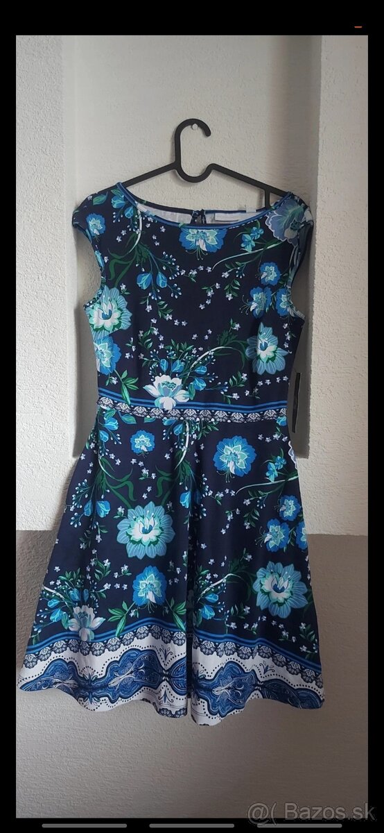 Kratšie modro-zeleno-čierne šaty s kvetinovým vzorom.