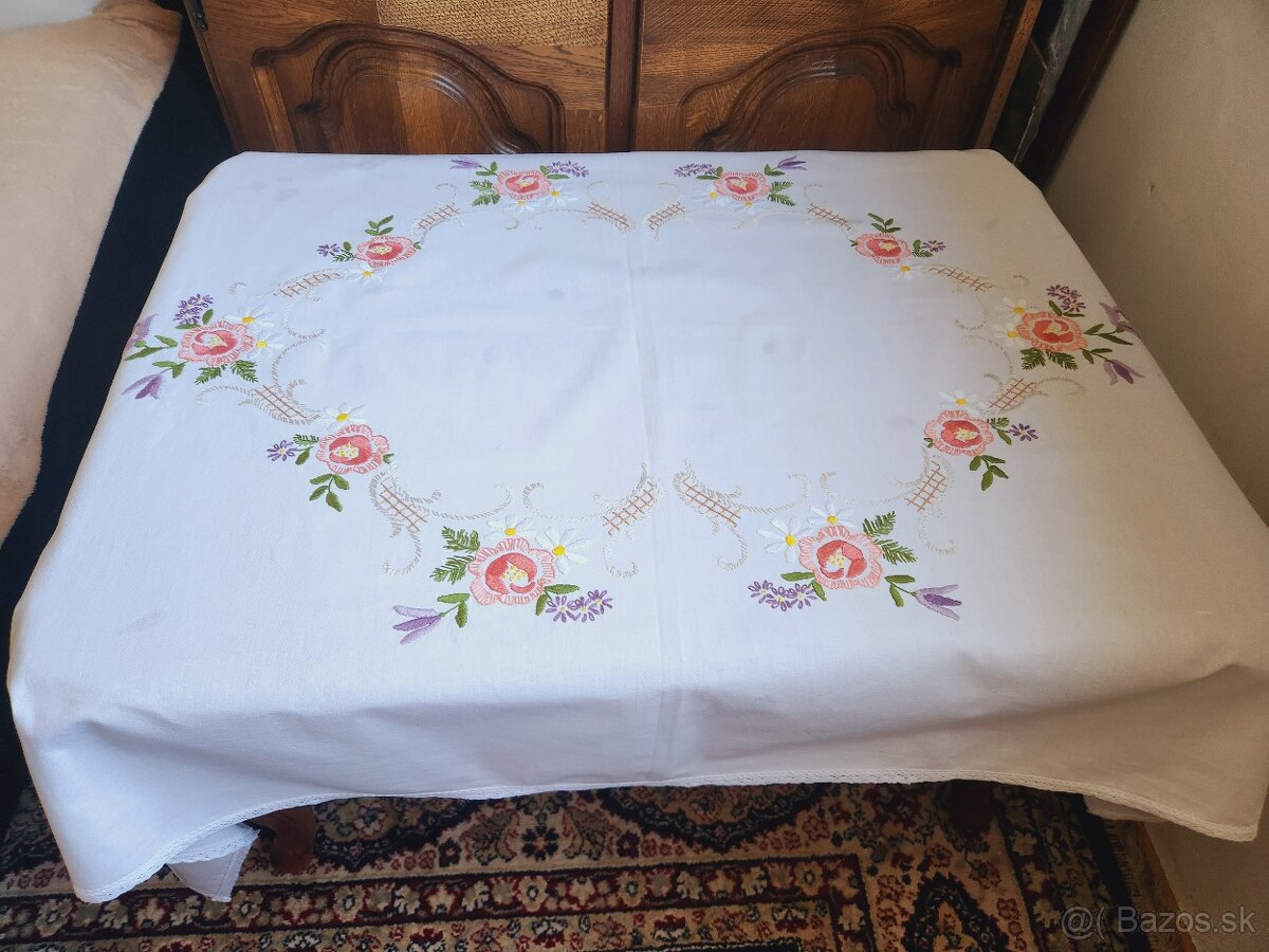 Krásny biely obrus zdobený výšivkou ruží, margaretiek a zvo