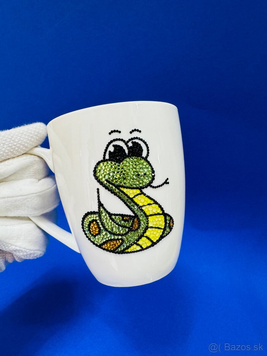 Šálka zdobená kamienkami v tvare hada.