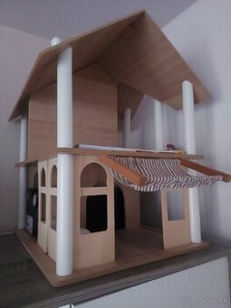 Drevený domček s postavičkami a nábytkom.