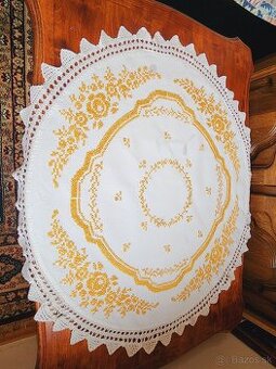 Krásny biely okrúhly ľanový obrus bohato zdobený žltou výšiv