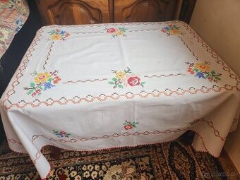 Krásny biely obrus zdobený vyšívanými modrými, červenými a ž