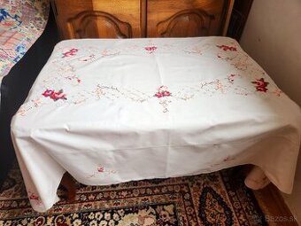 Krásny maslový obrus zdobený červenými ružami, bielymi a hne