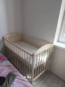 Drevená polohovateľná postieľka.