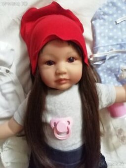 Realistická bábika v červenej šatke