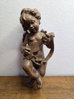 Starožitná drevená socha anjelíčka (putta) s nástrojom
