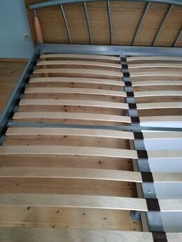 Kovová posteľ s dubovymi nohami