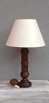 Lampa s masívnou drevenou nohou.