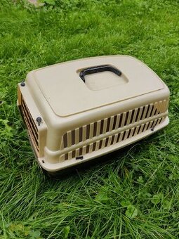 prenosná klietka a 2 knihy