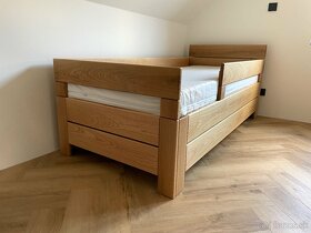 Dubová posteľ s detskými zábranami a úložným priestorom