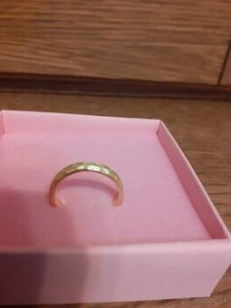 Pozlátený strieborný prsteň s tepaným povrchom.