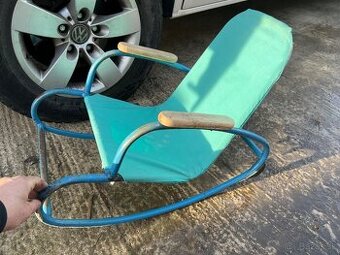 Staré detské kovové hojdacie kreslo.