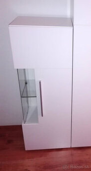 biela lesklá vitrína s preskleným rohom