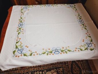 Krásny biely vianočný obrus zdobený zvončekmi, hviezdičkami