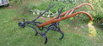 Starý kovový pluh s drevenými rúčkami