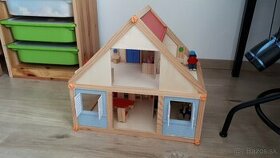 Drevený domček s nábytkom a bábikami