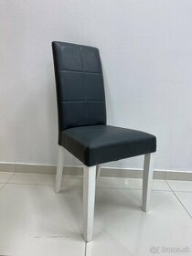 Moderná stolička s tmavosivou koženkou a bielymi nohami