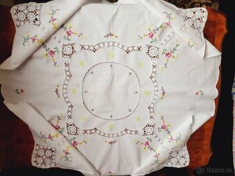 Krásny biely obrus zdobený háčkovanými vsadmi a výšivkou ruž