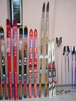 Lyžařská výbava - 9 párů lyží, hůlky, boty - 6